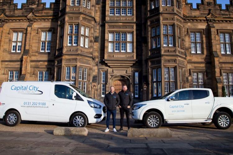 Capital City Electrical electricians standing beside their vans